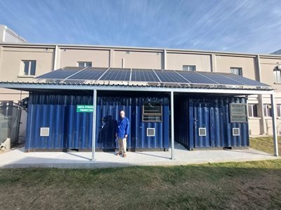 A person standing in front of a buildingDescription automatically generated